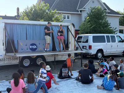 Students leading an outdoor kids program from a mobile stage